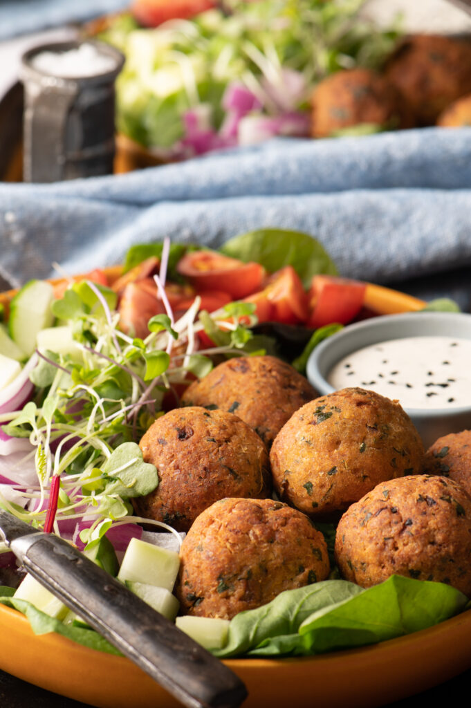 Falafel and salad with dip on wooden bowl