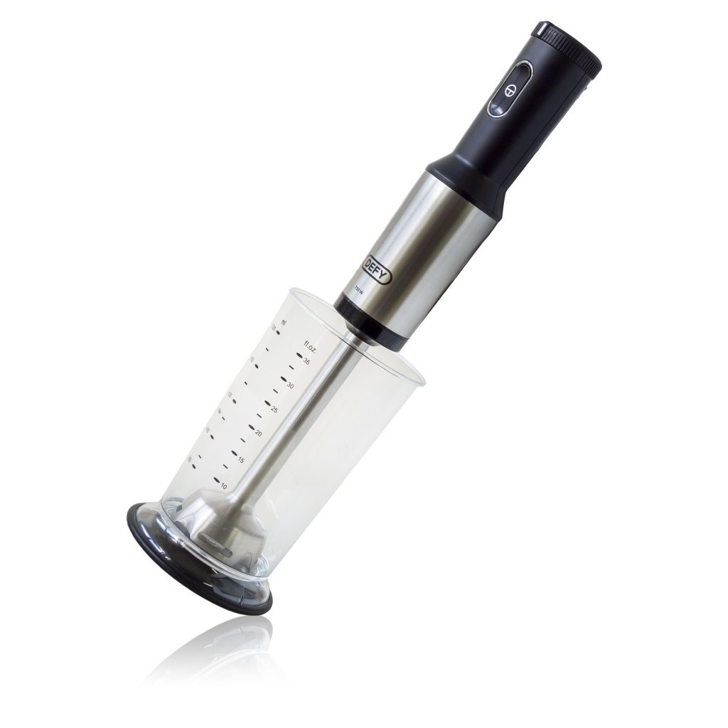 Silver and black hand blender in a measuring cip