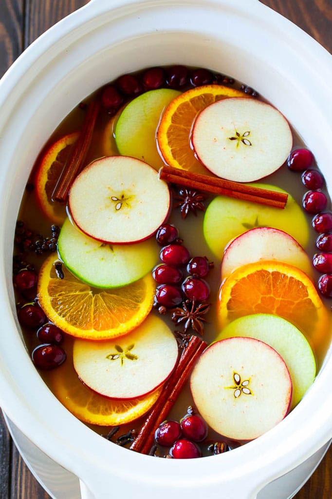 Apple cider with large slices of fruit, cranberries and spices