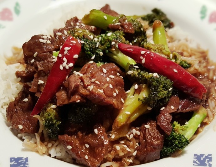Beef, broccoli, peppers and sesame seeds on a bed of rice