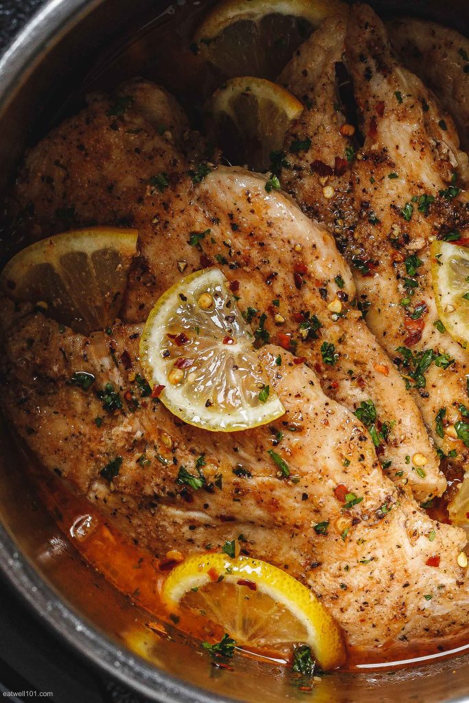 Chicken breasts cooked with herbs and lemon garnish