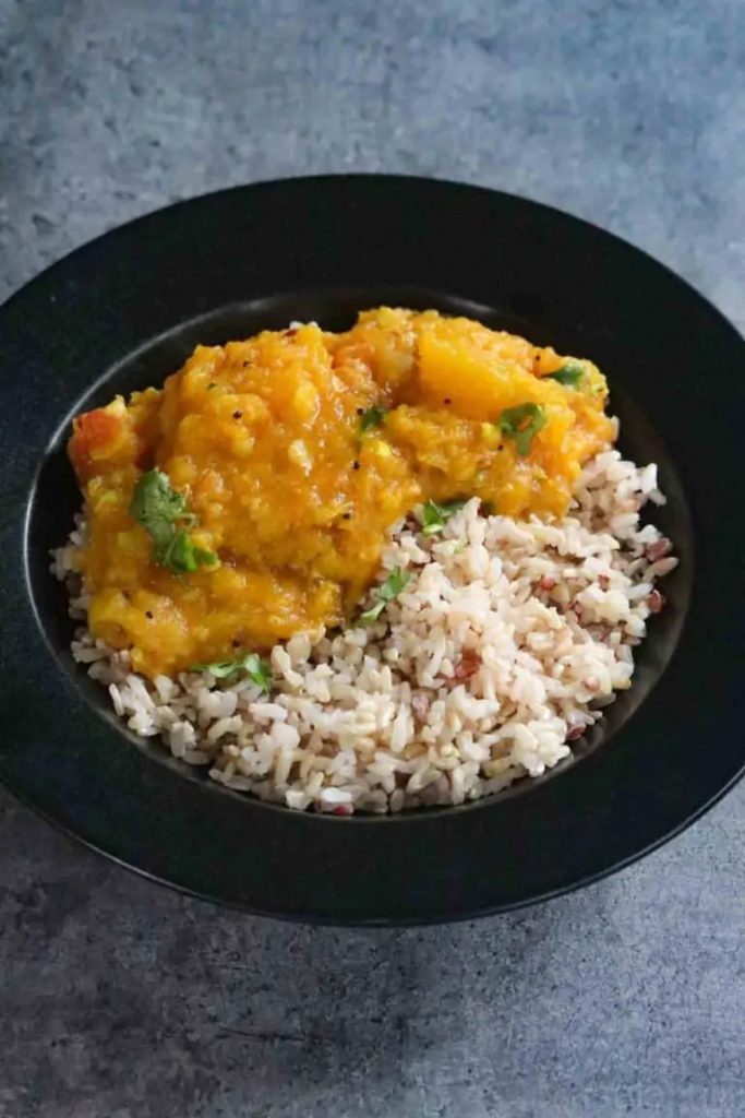 Pumpkin curry and wholegrain rice on black dish