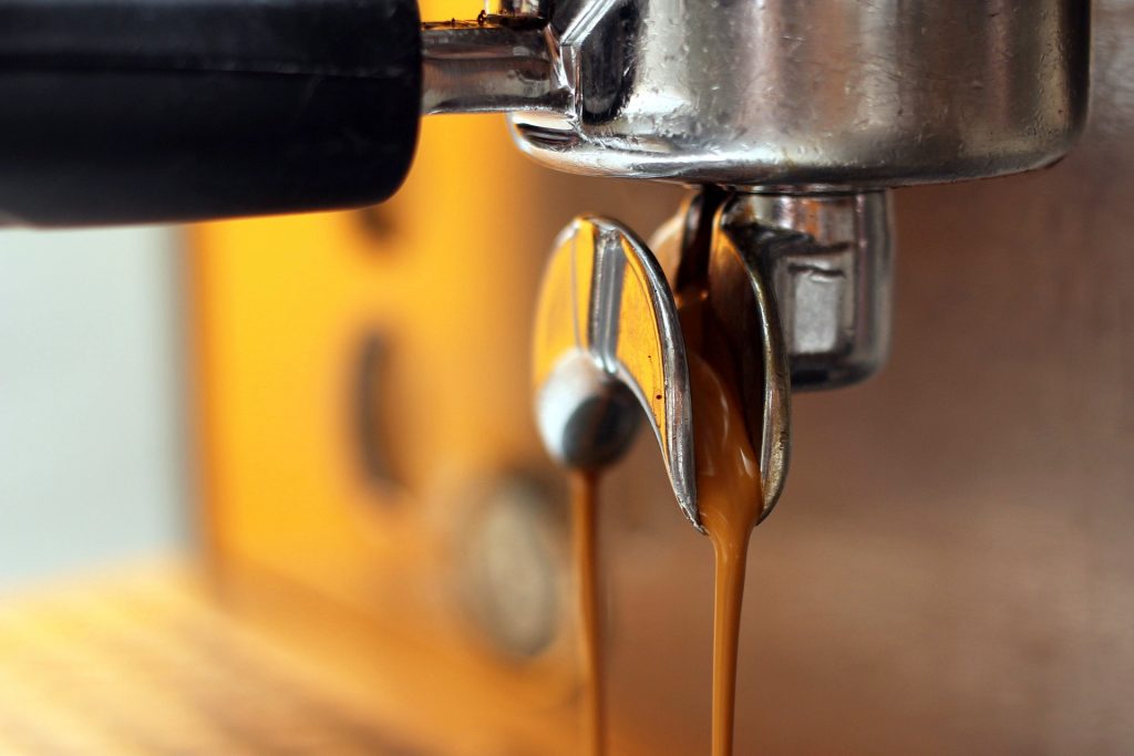 Close up of coffee pouring out of an espresso machine