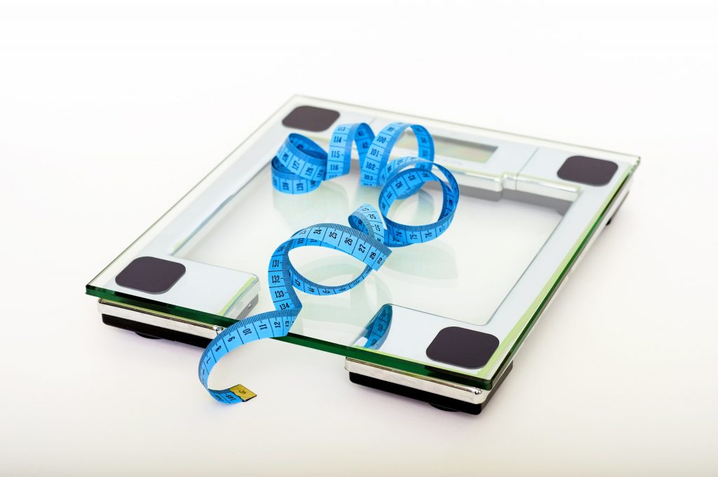 Glass bathroom scales with a blue tape measure
