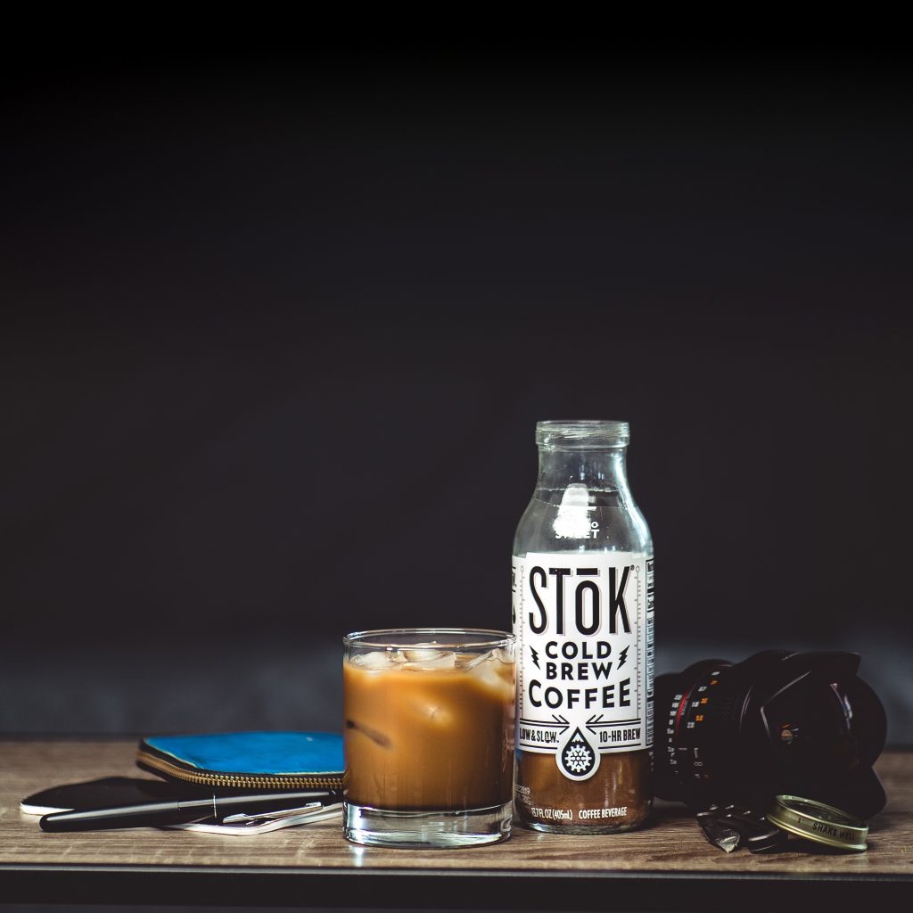 Bottle of Stok cold brew coffee poured in to glass of ice cubes